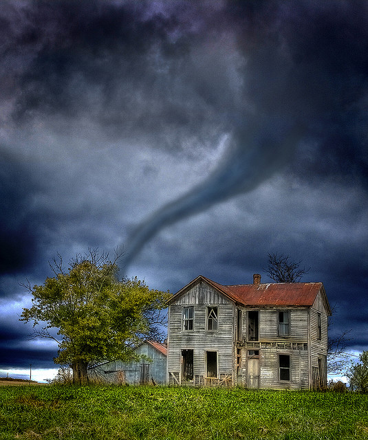 "photo of old house with tornado approaching in the distance"