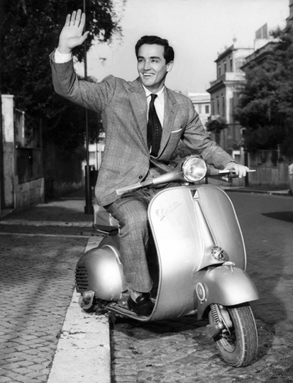 "vintage photograph of man on Vespa."
